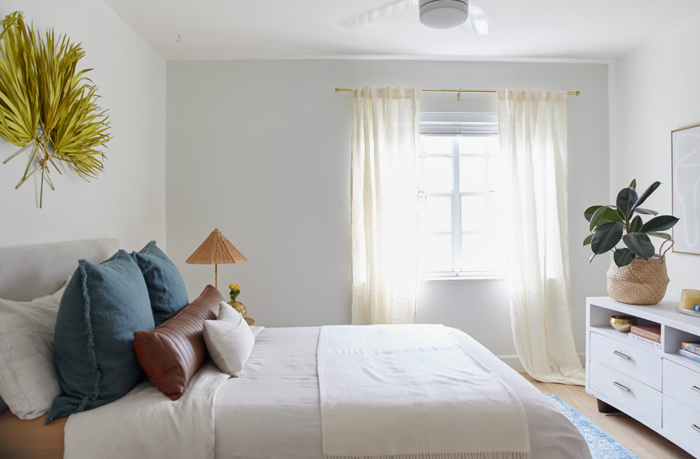 Diseño de habitación de invitados marinera pequeña con paredes blancas, suelo laminado y suelo beige