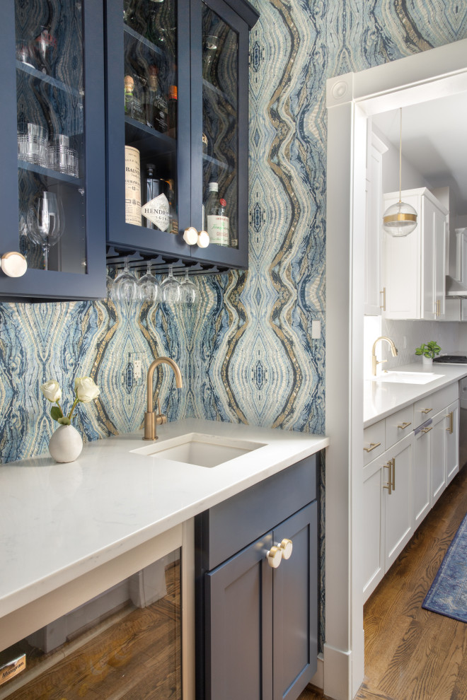 Design ideas for a small modern galley kitchen pantry in DC Metro with an undermount sink, recessed-panel cabinets, blue cabinets, quartz benchtops, blue splashback, stainless steel appliances, medium hardwood floors, no island, brown floor and white benchtop.