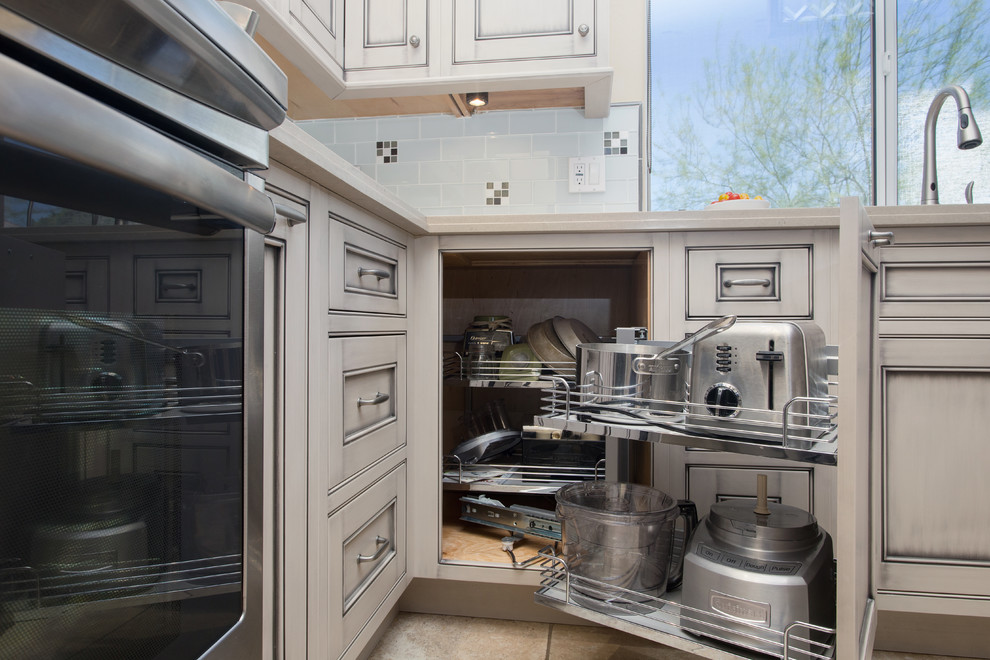 Example of a large transitional l-shaped ceramic tile open concept kitchen design in Phoenix with an undermount sink, beaded inset cabinets, gray cabinets, quartz countertops, white backsplash, glass tile backsplash, black appliances and an island