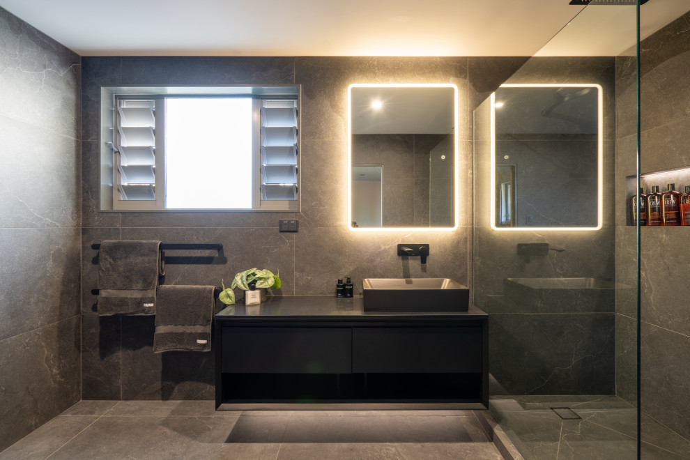 Inspiration for a mid-sized contemporary bathroom in Auckland with black cabinets, an open shower, a one-piece toilet, gray tile, ceramic tile, grey walls, ceramic floors, a vessel sink, engineered quartz benchtops, grey floor, an open shower, grey benchtops, a niche, a single vanity and a floating vanity.