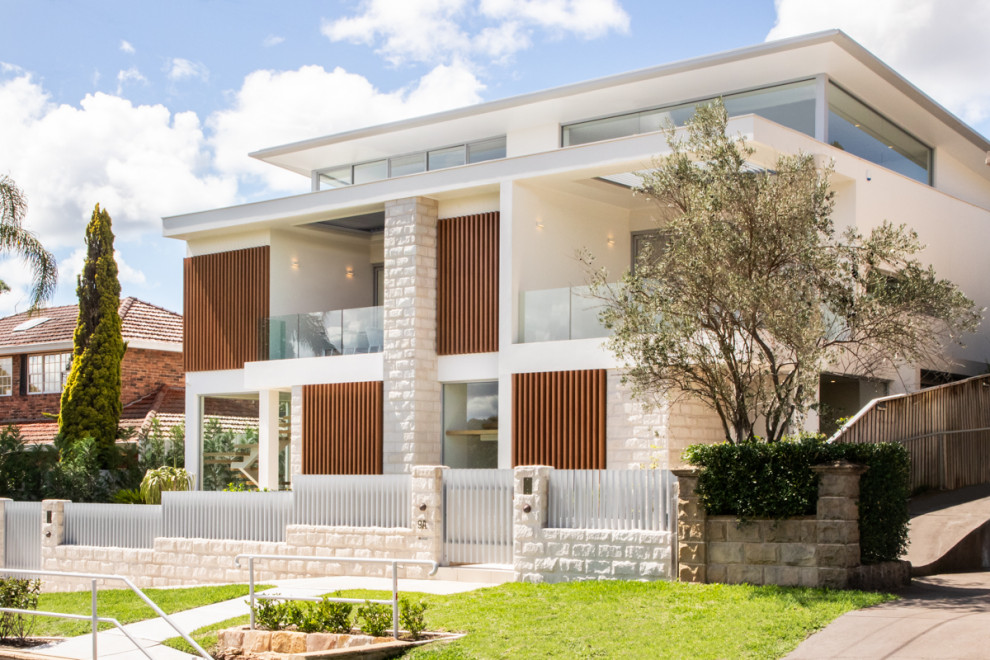 Contemporary two-storey grey duplex exterior in Sydney with stone veneer, a flat roof and a metal roof.