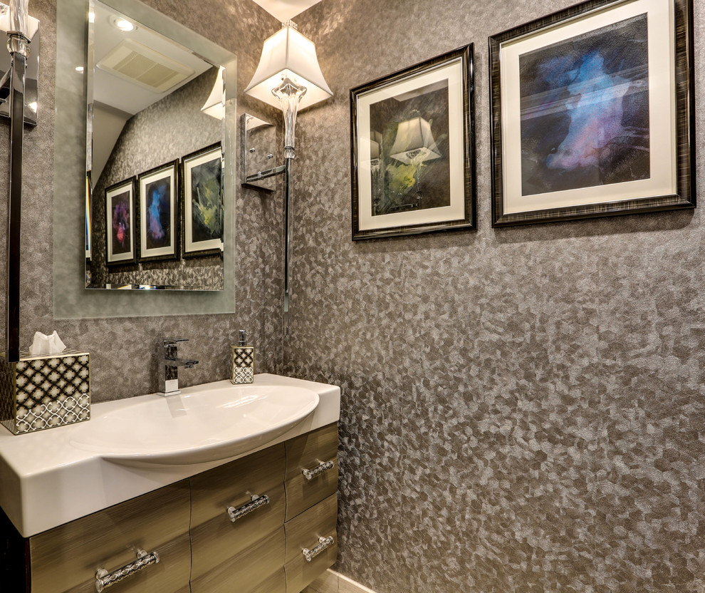 Photo of a small transitional powder room in Los Angeles with furniture-like cabinets, a one-piece toilet, grey walls, an integrated sink, solid surface benchtops and yellow cabinets.