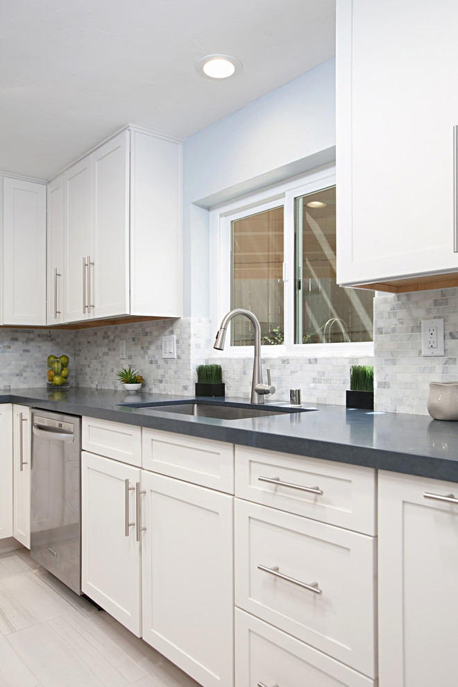 Inspiration for a large traditional l-shaped eat-in kitchen in San Diego with an undermount sink, shaker cabinets, white cabinets, quartz benchtops, multi-coloured splashback, stone tile splashback, stainless steel appliances, porcelain floors, with island, grey floor and blue benchtop.