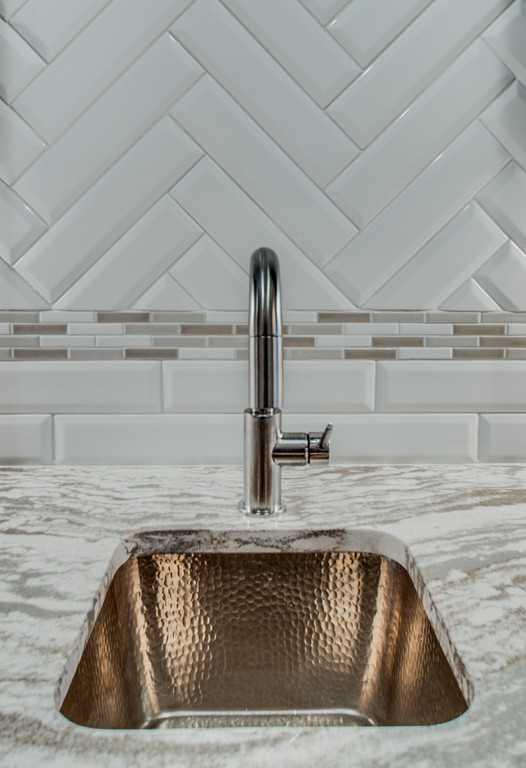 Inspiration for a mid-sized transitional galley dark wood floor and brown floor enclosed kitchen remodel in Nashville with an undermount sink, recessed-panel cabinets, blue cabinets, granite countertops, white backsplash, porcelain backsplash, stainless steel appliances and no island