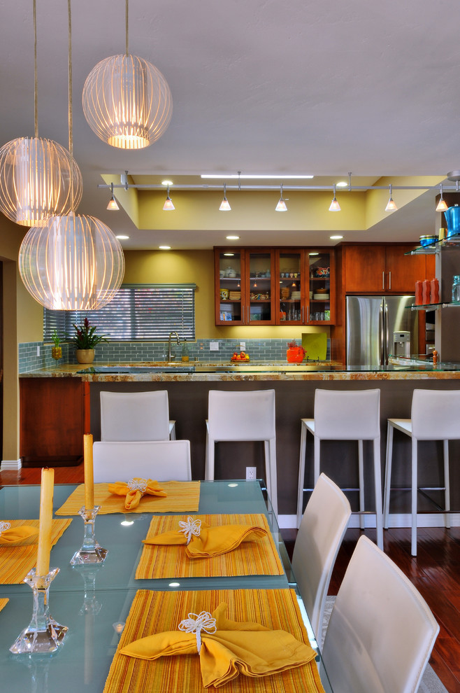 Photo of a large contemporary l-shaped eat-in kitchen in San Diego with a double-bowl sink, flat-panel cabinets, brown cabinets, granite benchtops, blue splashback, subway tile splashback, stainless steel appliances, dark hardwood floors, with island, brown floor and multi-coloured benchtop.