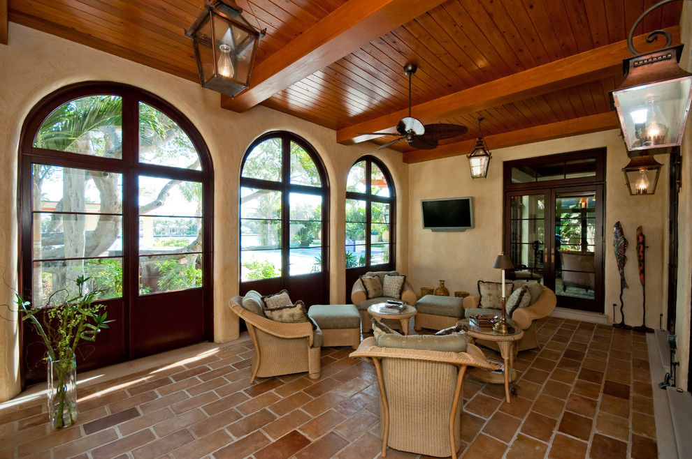 This is an example of a large mediterranean backyard verandah in Miami with tile.