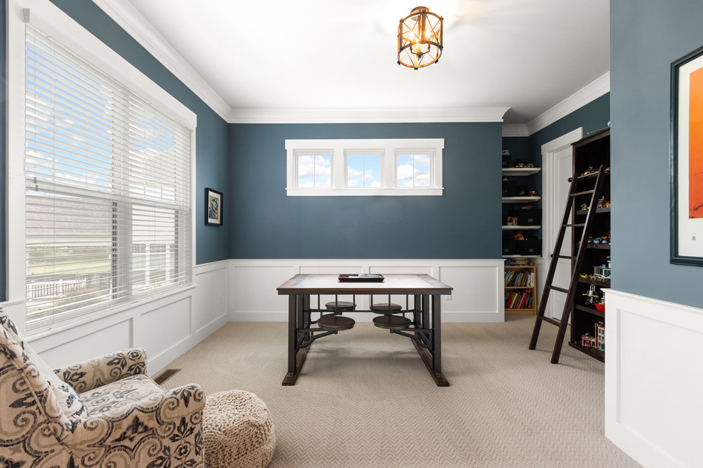 This is an example of a mid-sized arts and crafts home office in Columbus with a library, blue walls, carpet, no fireplace, a freestanding desk and beige floor.