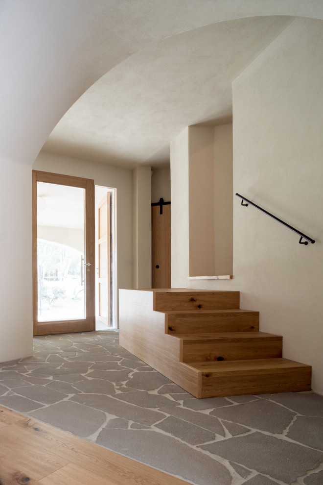 Ispirazione per un ingresso design con pareti beige e una porta in legno chiaro
