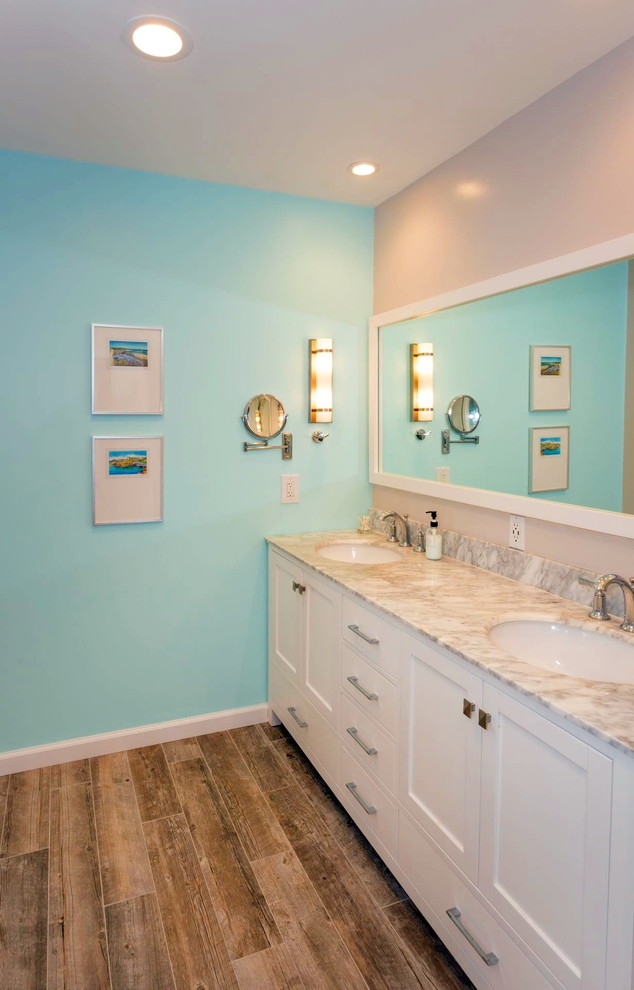 Inspiration for a mid-sized beach style master bathroom in San Francisco with blue walls, laminate floors, an undermount sink, brown floor, a hinged shower door, shaker cabinets, white cabinets, an alcove shower and engineered quartz benchtops.