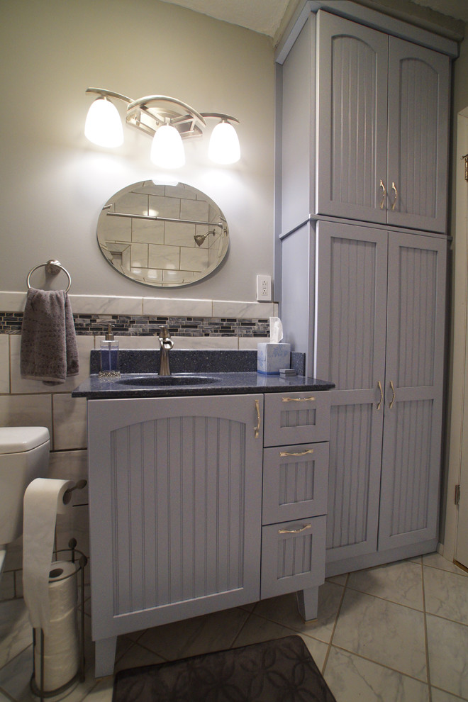 This is an example of a small country kids bathroom in St Louis with an integrated sink, recessed-panel cabinets, grey cabinets, black and white tile and ceramic floors.