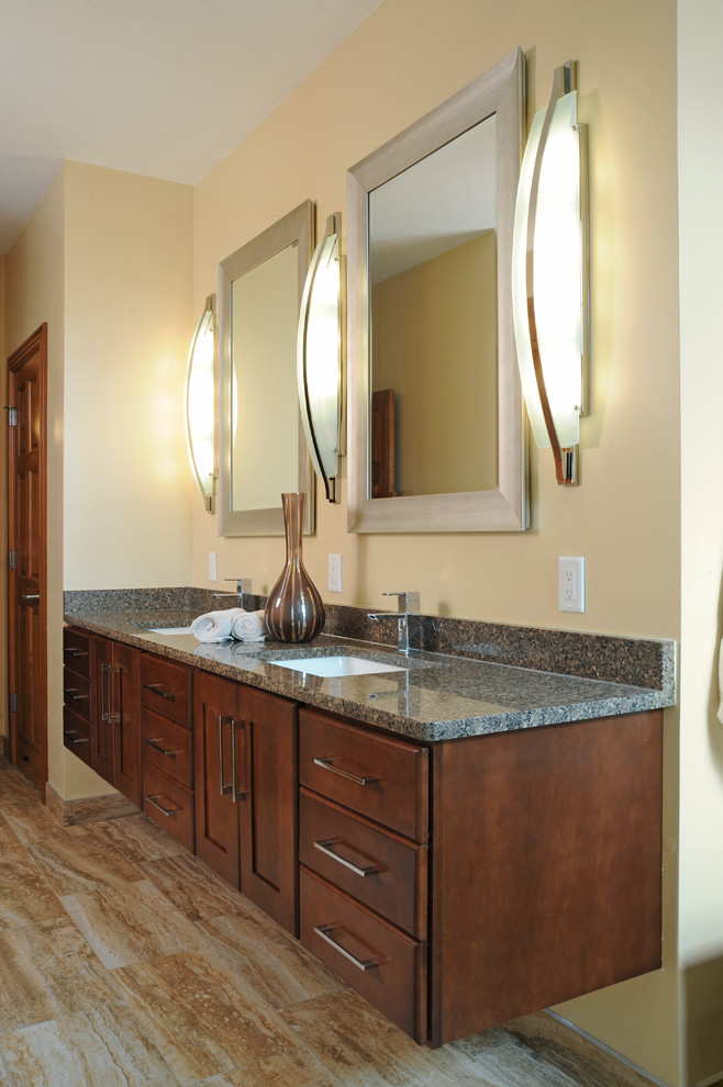 Photo of a mid-sized transitional master bathroom in Other with raised-panel cabinets, dark wood cabinets, a corner shower, beige walls, porcelain floors, an undermount sink and granite benchtops.