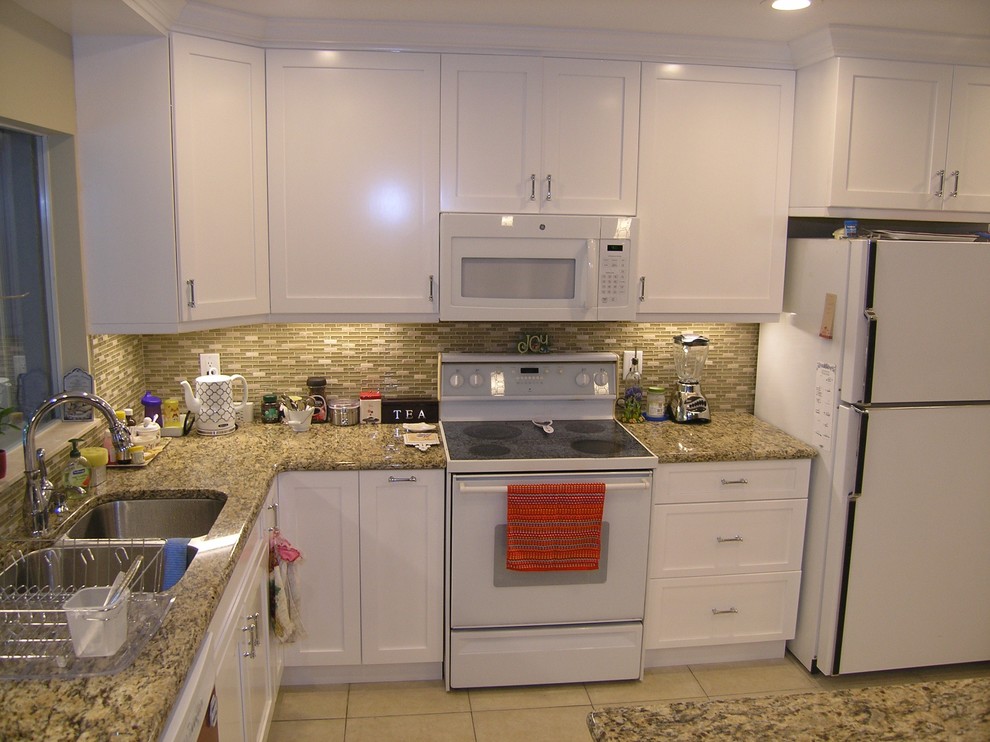 Photo of a mid-sized traditional u-shaped eat-in kitchen in Tampa with a double-bowl sink, shaker cabinets, white cabinets, granite benchtops, green splashback, matchstick tile splashback, stainless steel appliances, ceramic floors and with island.