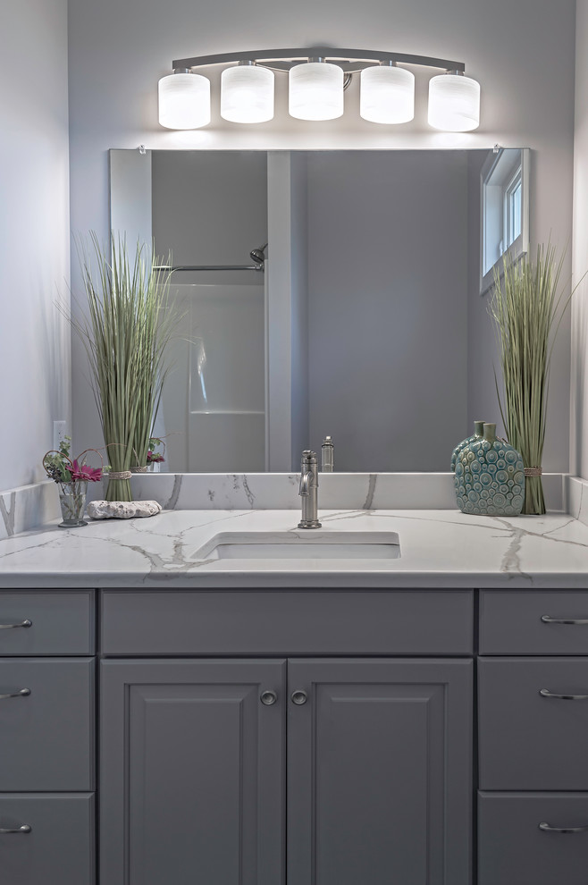 Design ideas for a small arts and crafts master bathroom in Providence with raised-panel cabinets, grey cabinets, a two-piece toilet, gray tile, ceramic tile, grey walls, ceramic floors, an undermount sink and engineered quartz benchtops.