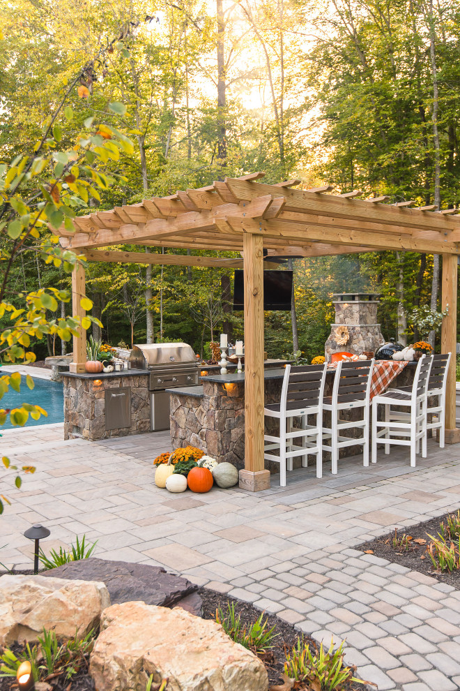 Large traditional backyard patio in Richmond with concrete pavers and a pergola.