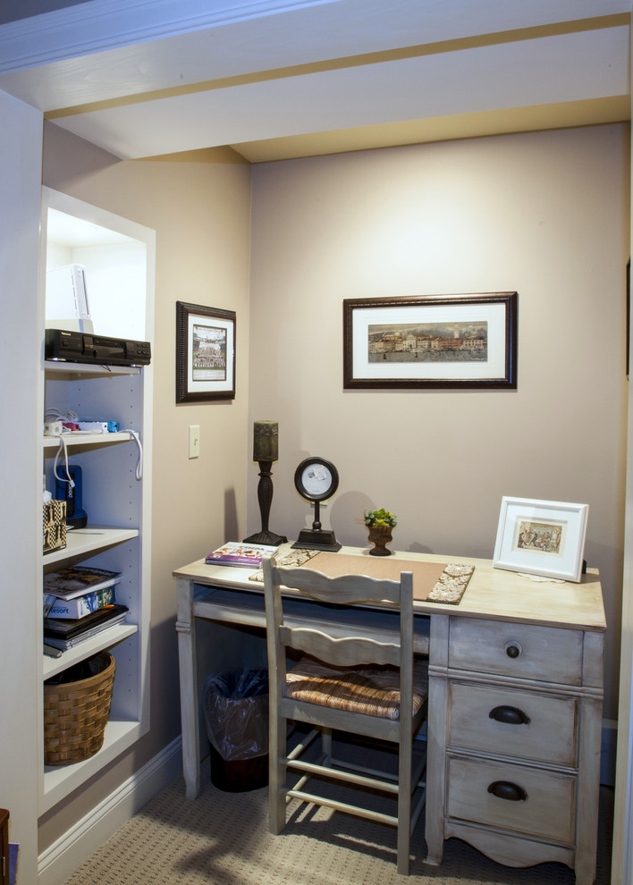 This is an example of a small transitional study room in Providence with beige walls, carpet and a freestanding desk.