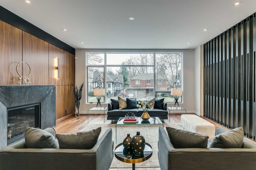 Contemporary formal enclosed living room in Toronto with medium hardwood floors, a standard fireplace and brown floor.