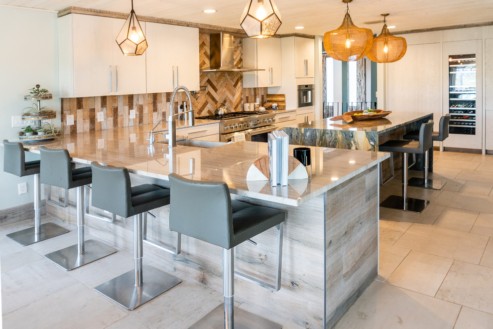 This is an example of a beach style u-shaped kitchen in Jacksonville with a farmhouse sink, flat-panel cabinets, white cabinets, stainless steel appliances, with island, grey floor and grey benchtop.