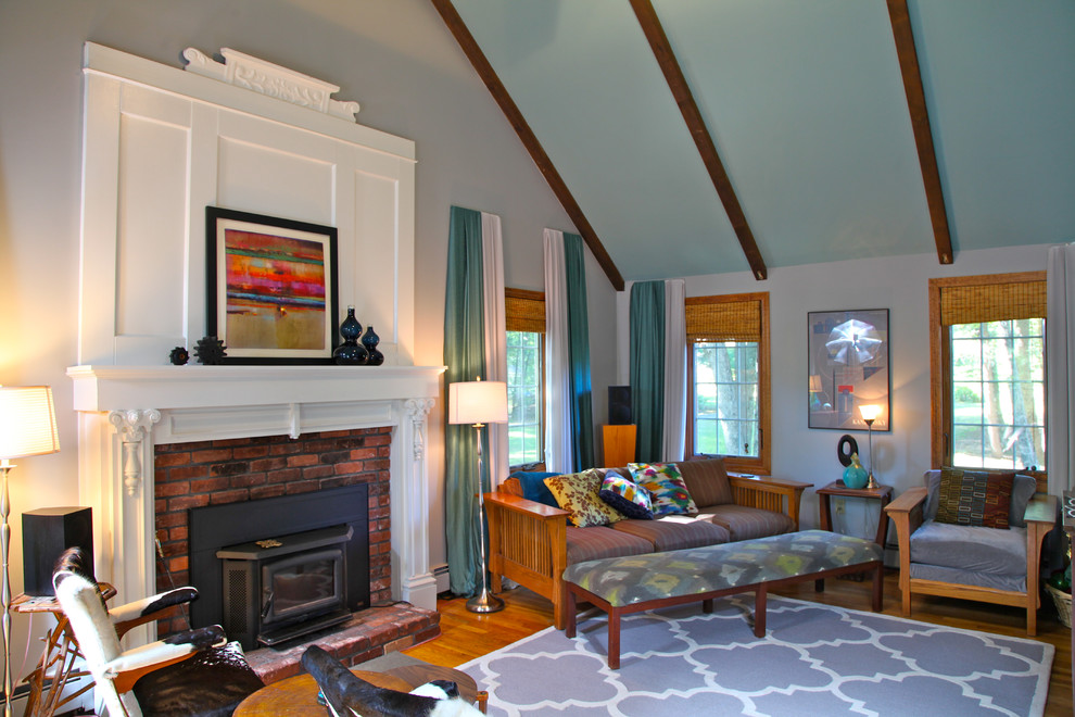 This is an example of a mid-sized traditional enclosed family room in Boston with white walls, medium hardwood floors, a standard fireplace, a brick fireplace surround and a freestanding tv.