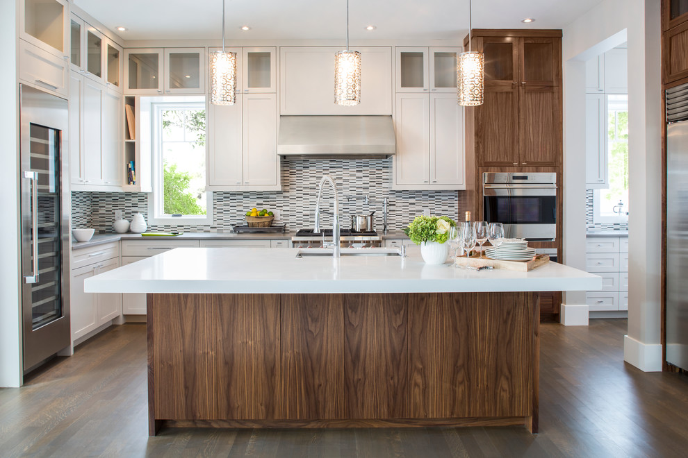 Inspiration for a large transitional l-shaped dark wood floor open concept kitchen remodel in Calgary with an undermount sink, shaker cabinets, white cabinets, multicolored backsplash, stainless steel appliances, an island, quartz countertops and matchstick tile backsplash