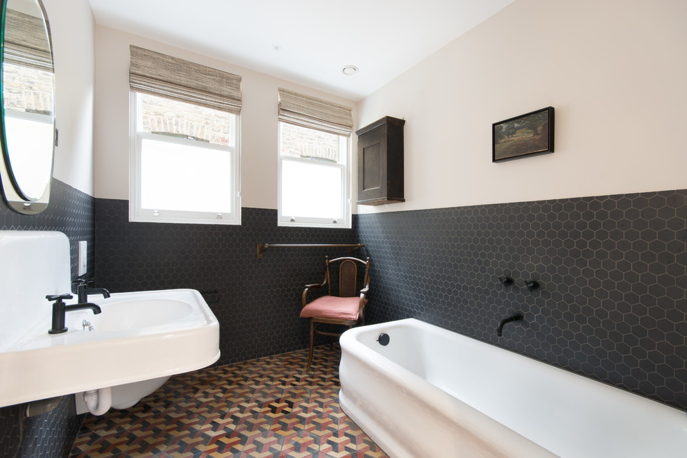 Photo of a transitional master bathroom in London with black tile, mosaic tile, white walls, mosaic tile floors, a wall-mount sink and multi-coloured floor.