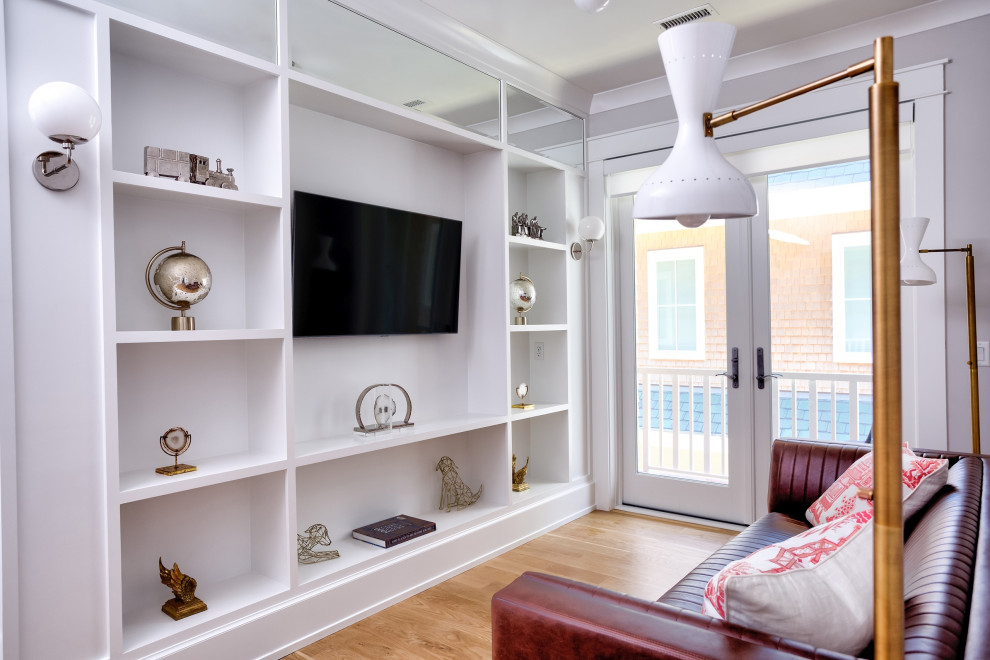Immagine di un ampio soggiorno minimal aperto con libreria, pareti bianche, pavimento in legno massello medio, TV a parete e pavimento marrone