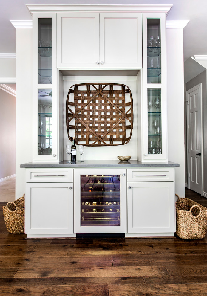 Inspiration for a transitional single-wall home bar in Houston with white cabinets, glass-front cabinets, dark hardwood floors and brown floor.
