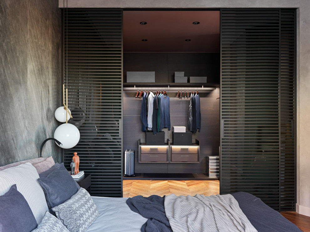 Mid-sized contemporary men's storage and wardrobe in Saint Petersburg with flat-panel cabinets, grey cabinets, medium hardwood floors and brown floor.