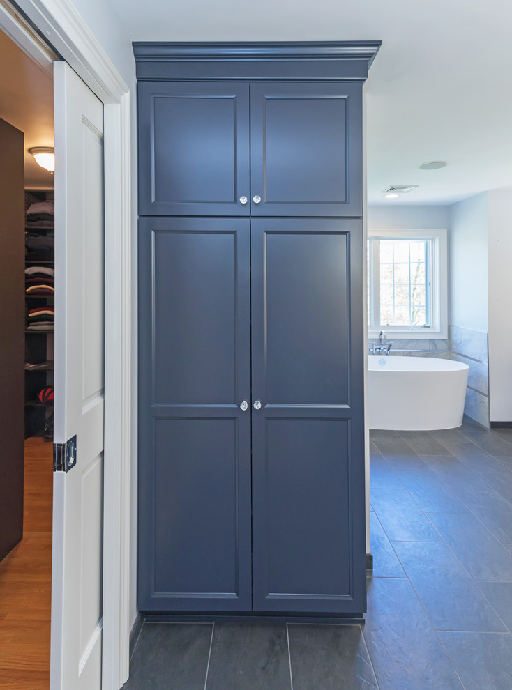 Example of a large transitional master gray tile and porcelain tile porcelain tile and gray floor freestanding bathtub design in Philadelphia with flat-panel cabinets, blue cabinets, a two-piece toilet, gray walls, an undermount sink, granite countertops and gray countertops