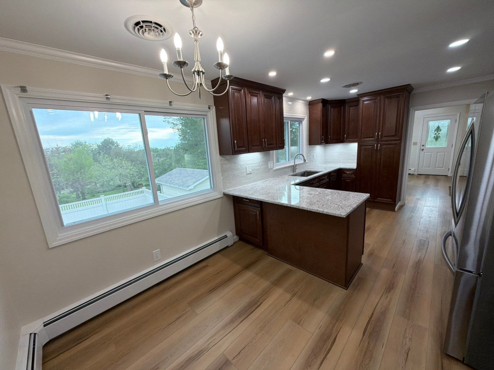USCD cabinetry accompanied granite countertops, porcelain tile backsplash and Ca