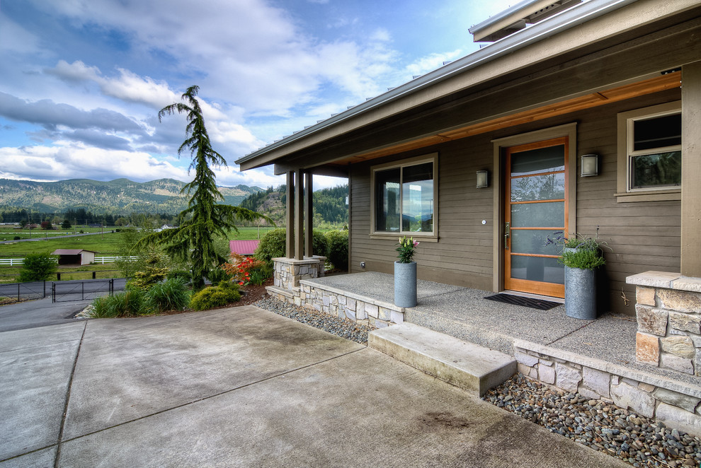 Transitional verandah in Seattle with concrete slab and a roof extension.