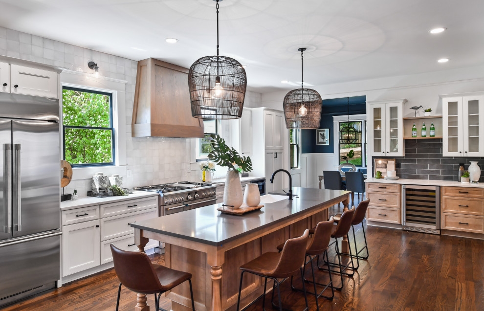 Inspiration for a large transitional l-shaped kitchen in Atlanta with a farmhouse sink, quartz benchtops, white splashback, stainless steel appliances, dark hardwood floors, brown floor, recessed-panel cabinets, white cabinets, with island and white benchtop.
