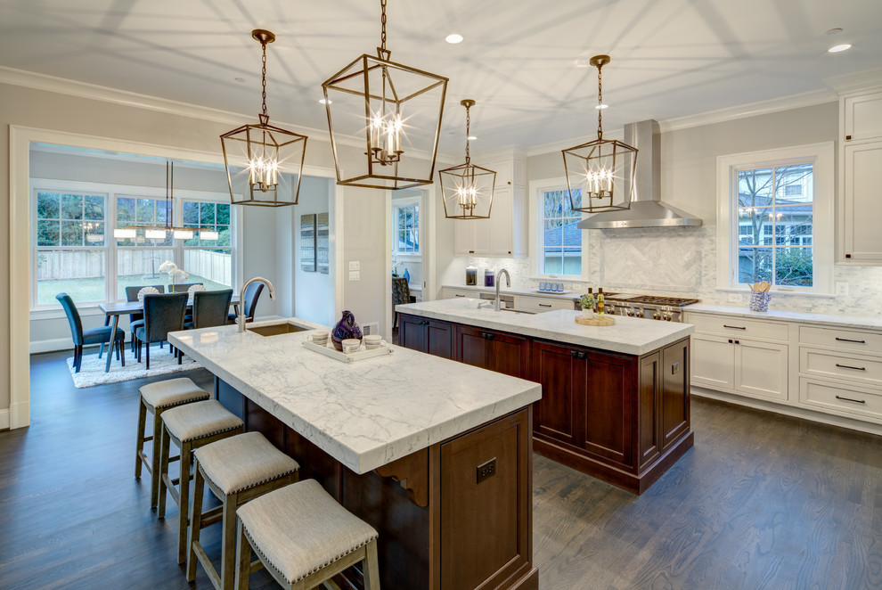 Inspiration for a huge transitional l-shaped dark wood floor and brown floor enclosed kitchen remodel in DC Metro with recessed-panel cabinets, white cabinets, granite countertops, gray backsplash, marble backsplash, paneled appliances, two islands and gray countertops