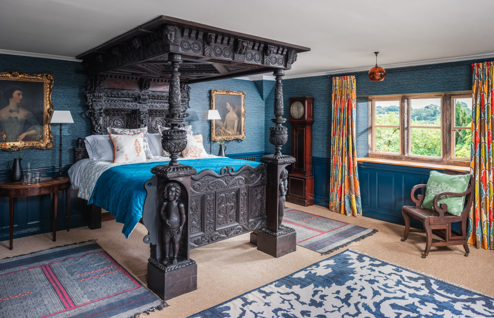 This is an example of a farmhouse master bedroom in Gloucestershire with blue walls, carpet, beige floors and panelled walls.