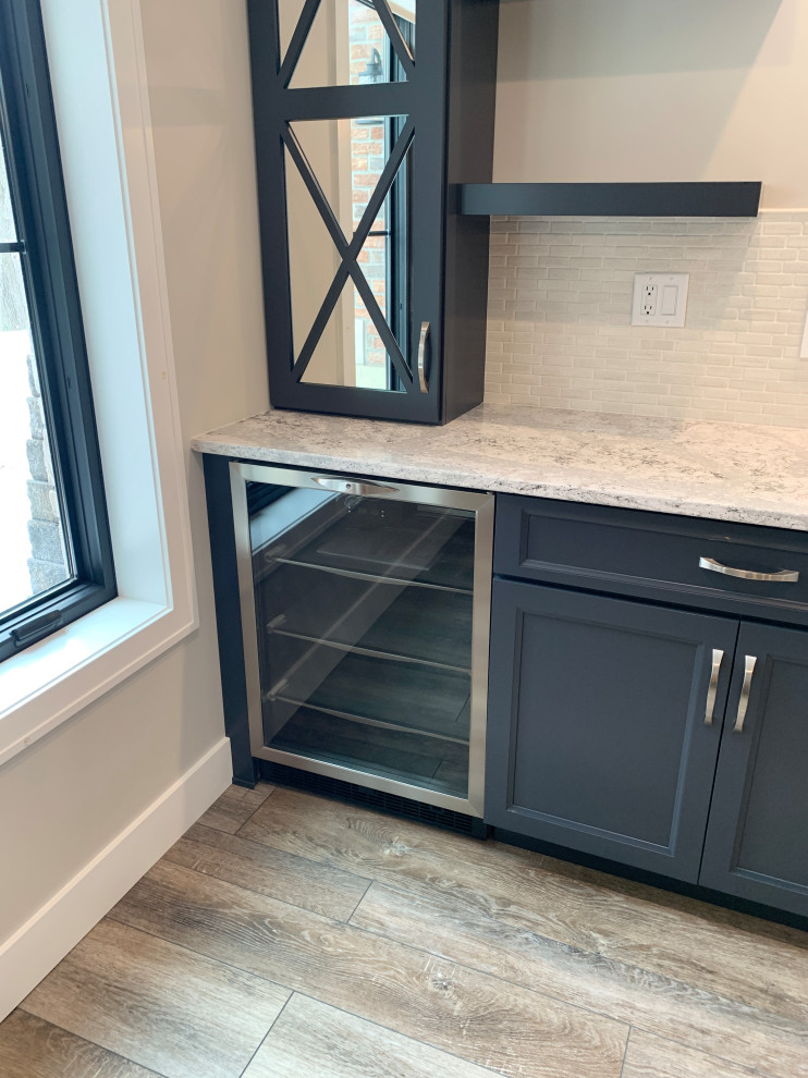 Photo of a mid-sized single-wall wet bar in Other with an undermount sink, flat-panel cabinets, blue cabinets, quartz benchtops, beige splashback, grey floor and beige benchtop.
