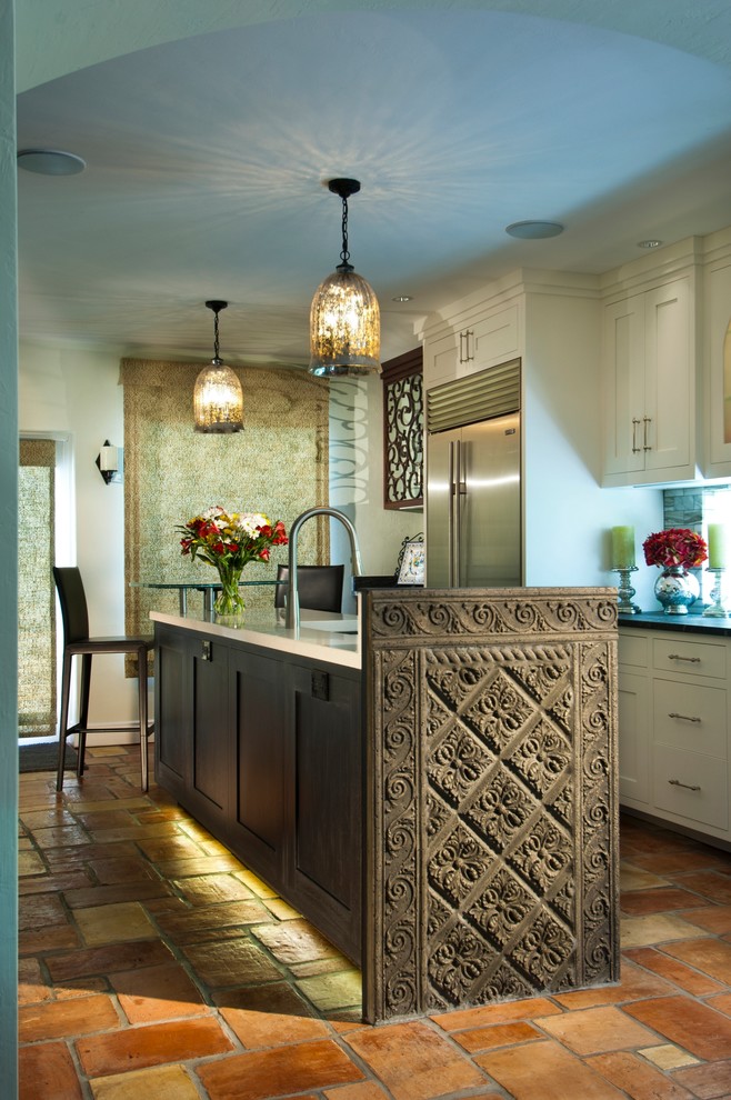 Photo of a mediterranean eat-in kitchen in Miami with recessed-panel cabinets and white cabinets.