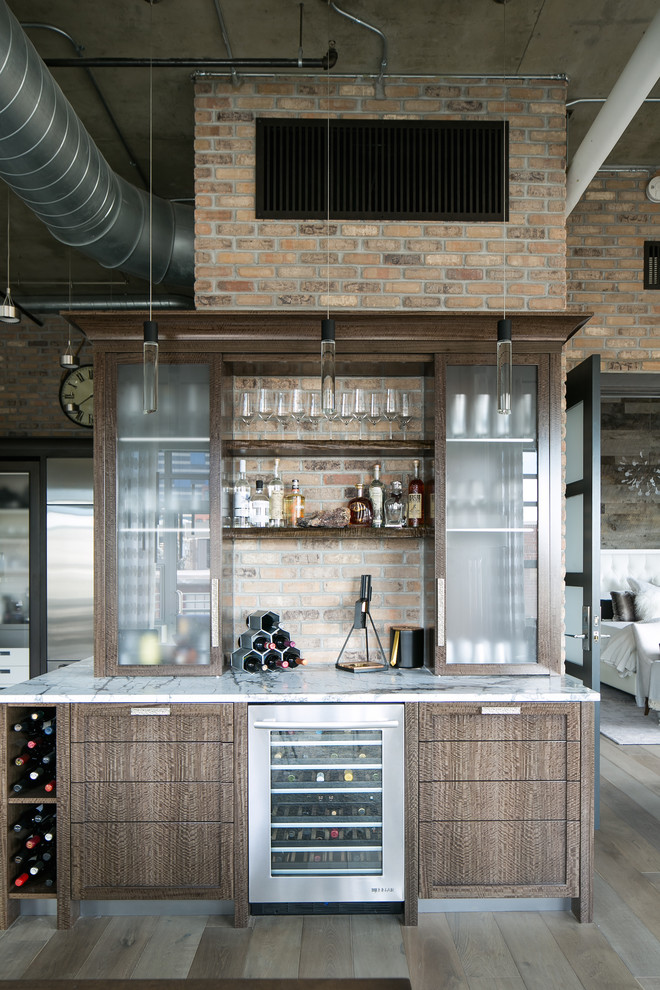 Inspiration for a mid-sized industrial single-wall medium tone wood floor and gray floor home bar remodel in Denver with flat-panel cabinets, quartzite countertops, gray backsplash, brick backsplash, stainless steel appliances, no island, gray countertops and medium tone wood cabinets