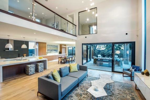 Large contemporary open concept living room in Melbourne with grey walls, light hardwood floors, a wall-mounted tv and brown floor.