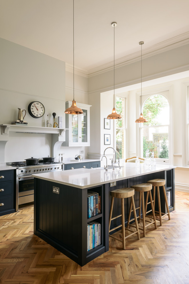 Inspiration for a large traditional l-shaped eat-in kitchen in Other with a farmhouse sink, shaker cabinets, blue cabinets, solid surface benchtops, white splashback, stainless steel appliances, medium hardwood floors, with island and brown floor.