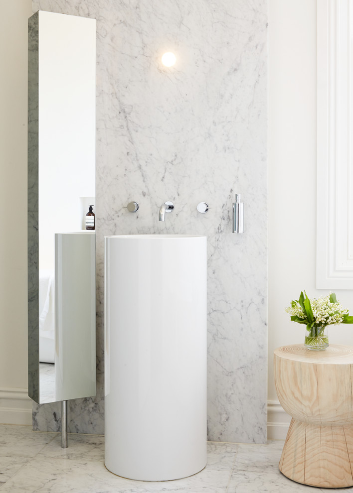 This is an example of a mid-sized modern master bathroom in Melbourne with a freestanding tub, gray tile, marble, white walls, a console sink, glass-front cabinets, marble floors and white floor.