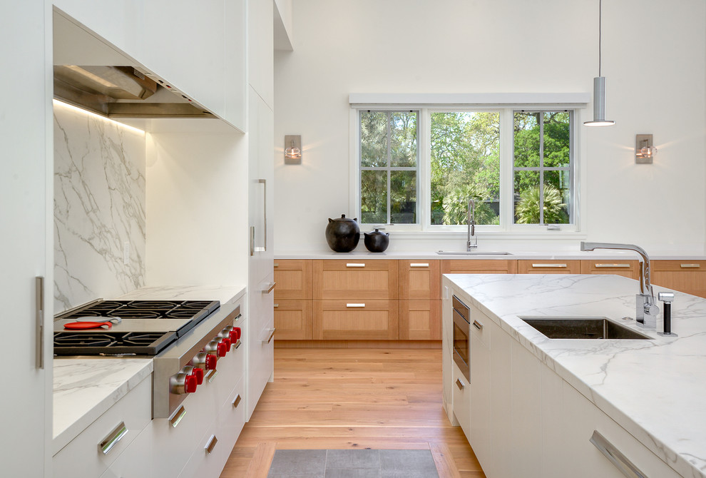 Photo of a contemporary kitchen in San Francisco with an undermount sink, flat-panel cabinets, white cabinets, grey splashback, stone slab splashback, stainless steel appliances, medium hardwood floors and with island.