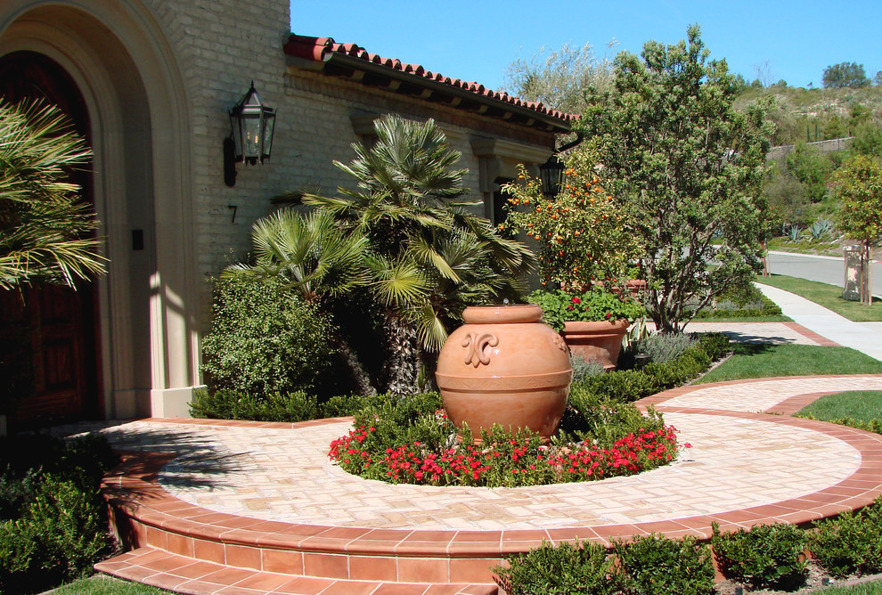 Inspiration for a mediterranean front yard garden in Los Angeles with a container garden and brick pavers.
