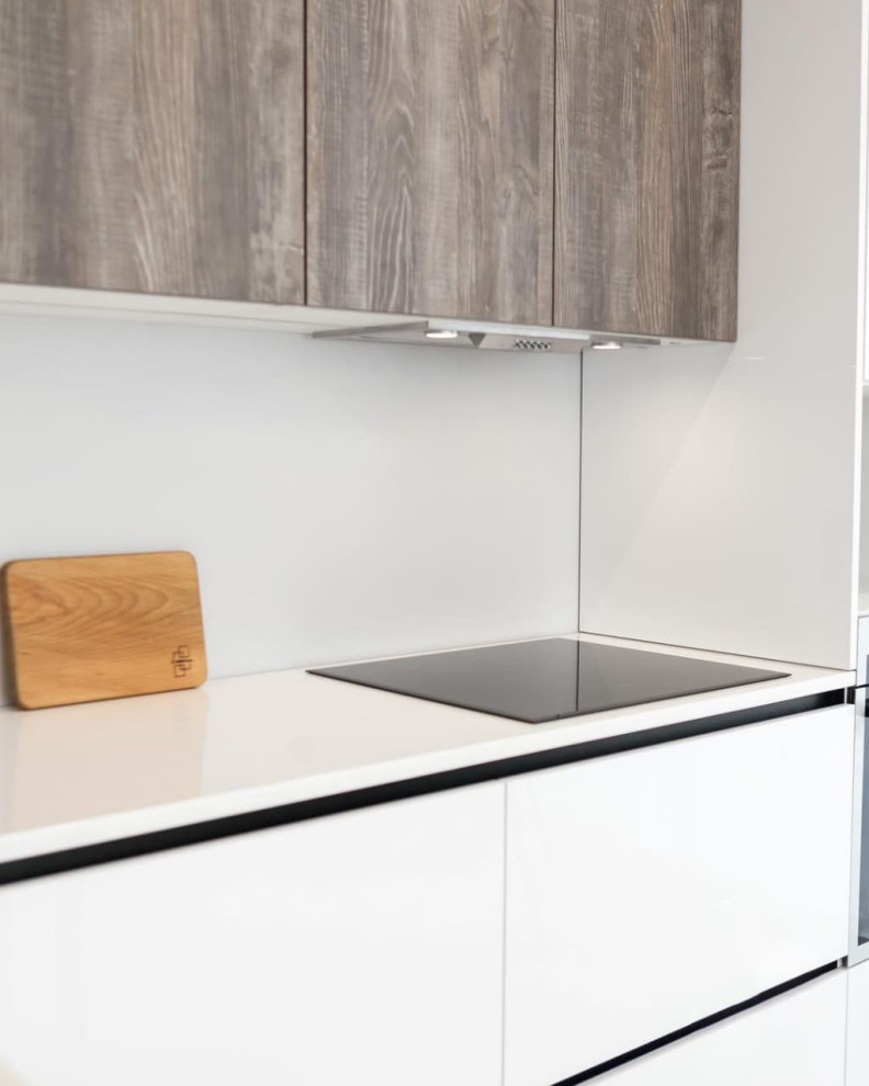 Современная серо-белая кухня в высокими шкафами и барной стойкой