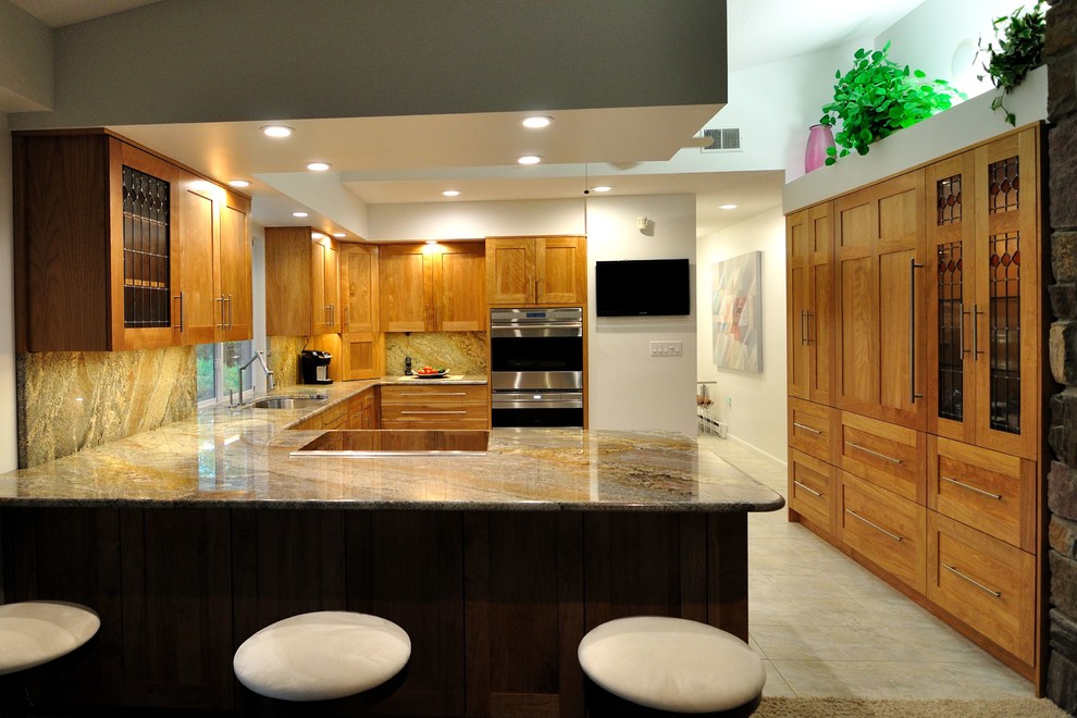 Photo of a transitional kitchen in Burlington with recessed-panel cabinets, medium wood cabinets, granite benchtops and stone slab splashback.