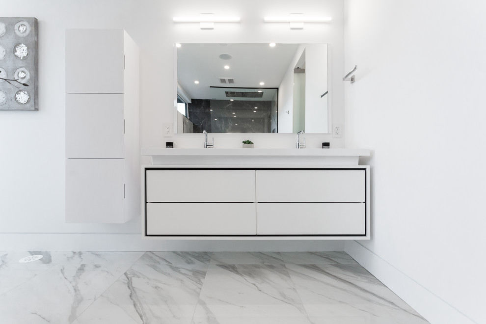 Photo of a large modern master bathroom in Toronto with flat-panel cabinets, yellow cabinets, a freestanding tub, a curbless shower, black tile, marble, white walls, marble floors, an undermount sink, engineered quartz benchtops, white floor, an open shower and white benchtops.