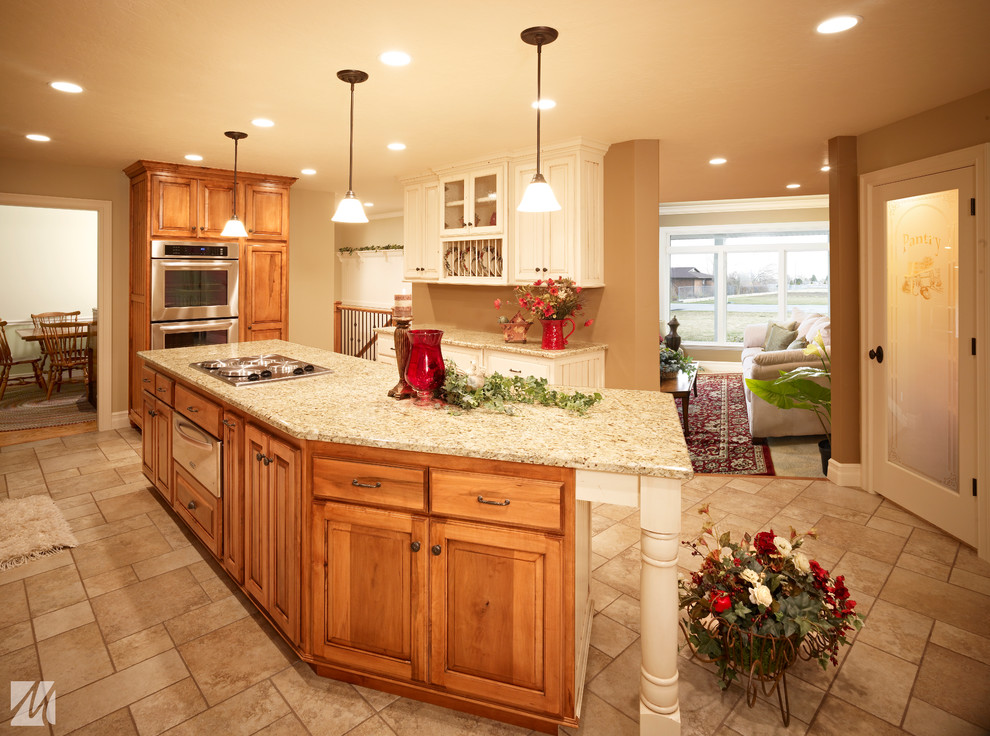 Mid-sized traditional l-shaped eat-in kitchen in Salt Lake City with a double-bowl sink, raised-panel cabinets, medium wood cabinets, granite benchtops, stainless steel appliances, ceramic floors and with island.