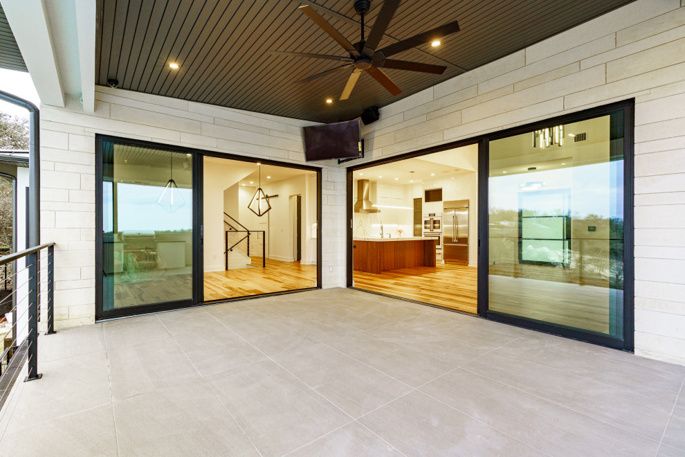 This is an example of a contemporary balcony in Austin with a roof extension.