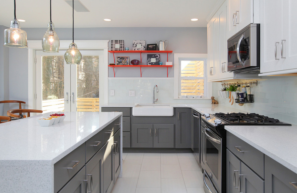 Inspiration for a large transitional l-shaped kitchen in Philadelphia with a farmhouse sink, shaker cabinets, white splashback, glass tile splashback, with island, white cabinets, quartzite benchtops, stainless steel appliances and porcelain floors.