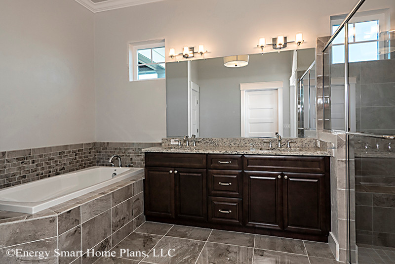 Design ideas for a mid-sized transitional master bathroom in Miami with an undermount sink, recessed-panel cabinets, dark wood cabinets, granite benchtops, a drop-in tub, a corner shower, a one-piece toilet, brown tile, ceramic tile, grey walls and ceramic floors.