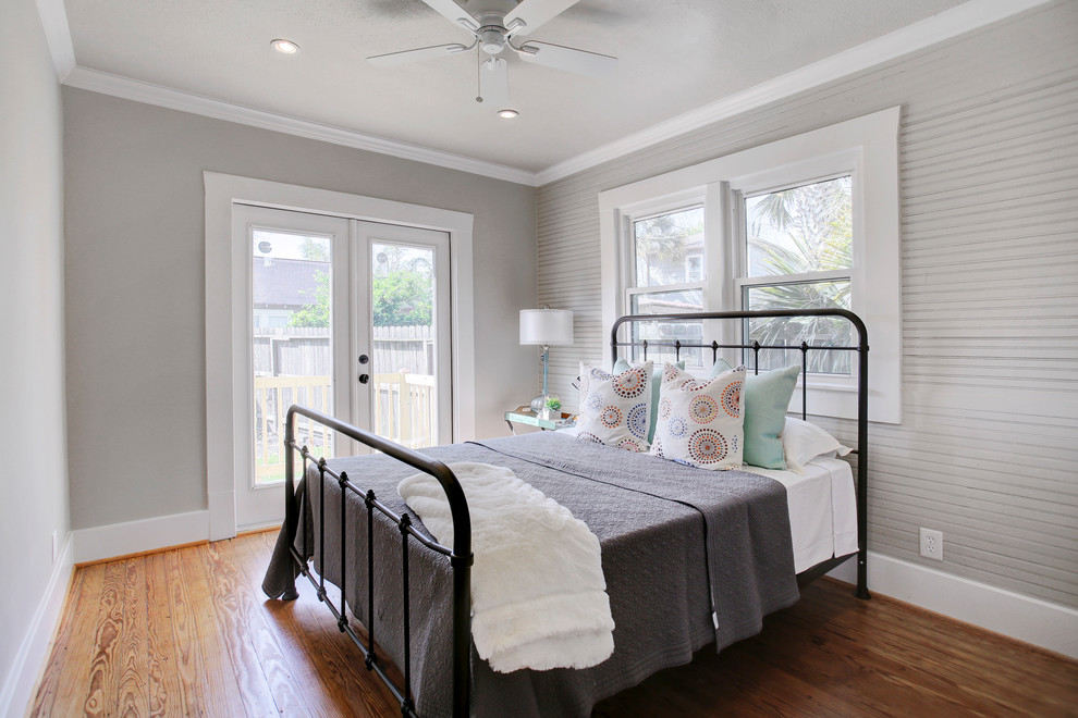 Design ideas for a mid-sized country guest bedroom in Houston with grey walls, medium hardwood floors and brown floor.