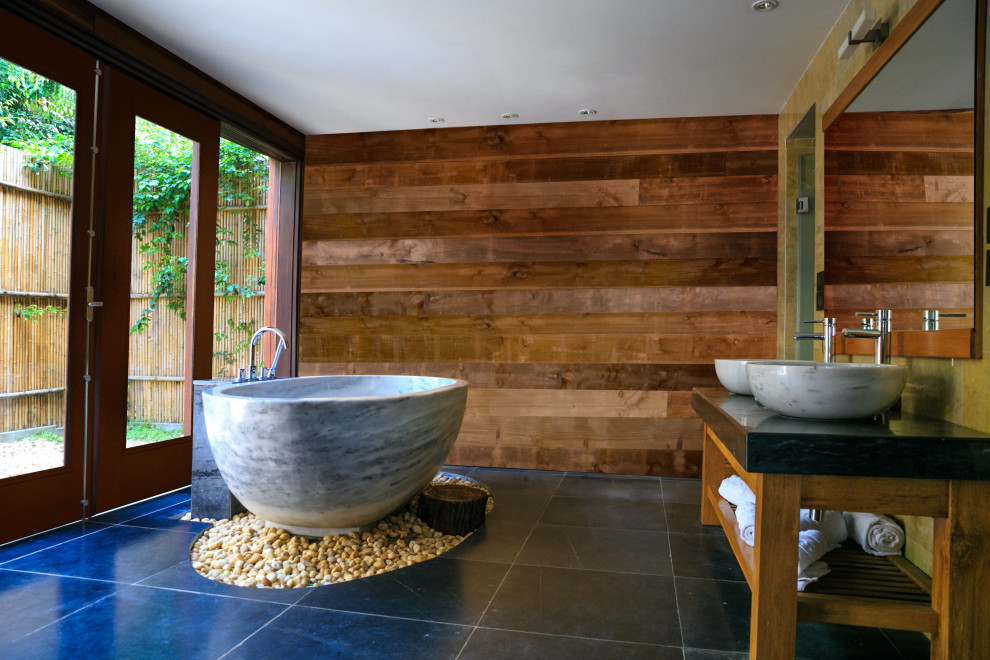 Стильный дизайн: главная ванная комната среднего размера в стиле рустика с японской ванной, коричневыми стенами, черной столешницей, тумбой под две раковины и подвесной тумбой - последний тренд